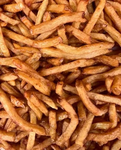 Gros plan sur des frites maison fraîchement coupées, dorées et croustillantes